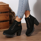 Black ankle boots featuring a lace-up design and metal buckle detail, offering a stylish and edgy look. 0