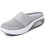 Light grey slip-on mules with a breathable upper and cushioned sole for casual comfort. 5