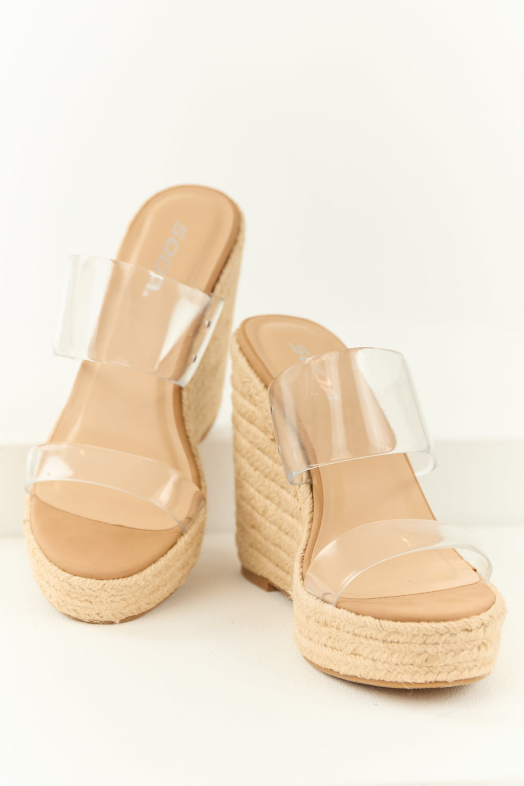 Beige espadrille wedge heels featuring clear lucite straps in a modern, summery style. 0