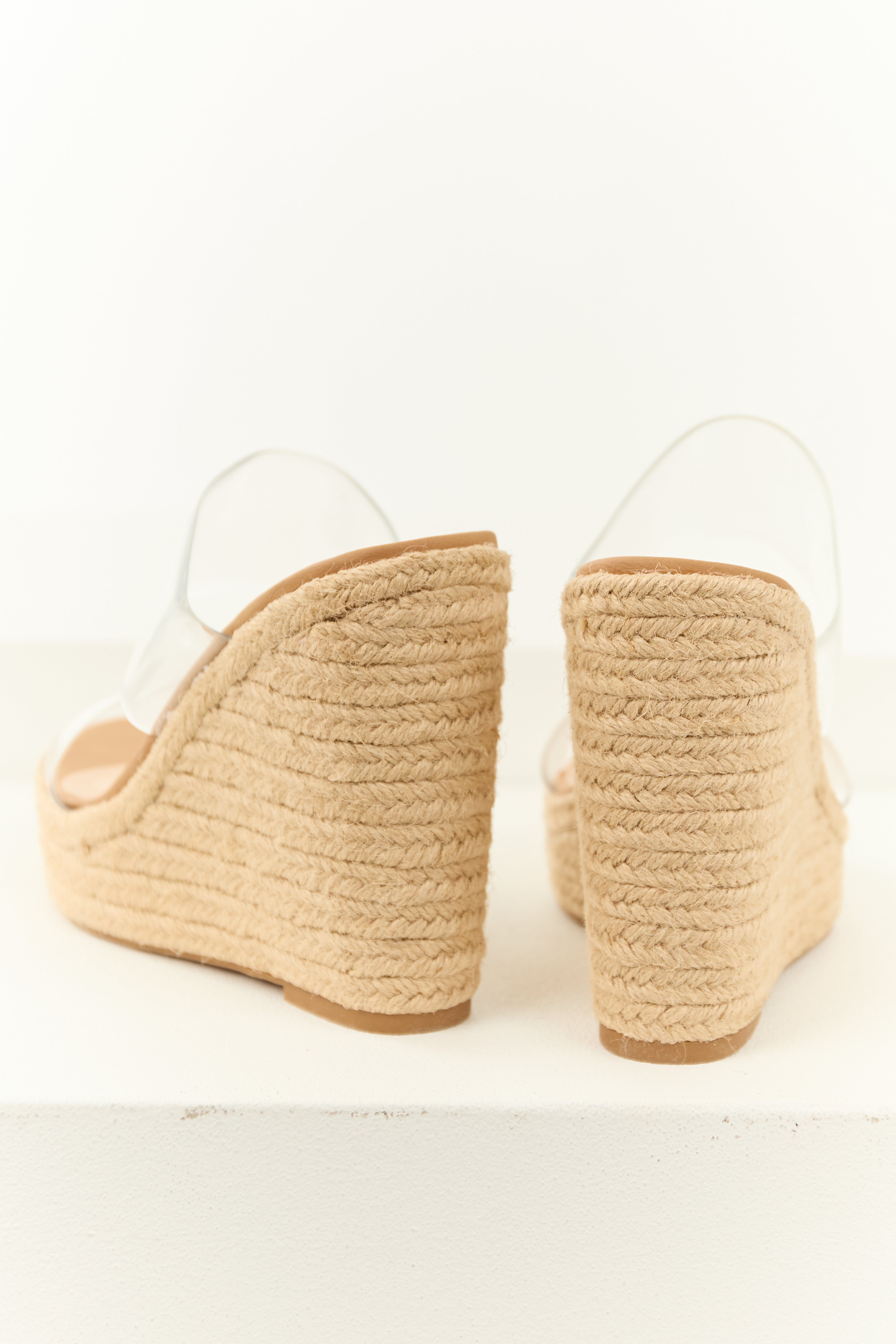 Beige espadrille wedge heels featuring clear lucite straps in a modern, summery style. 2