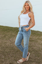 High-rise blue jogger jeans with a drawstring and pockets, featuring a relaxed fit and casual style. 2