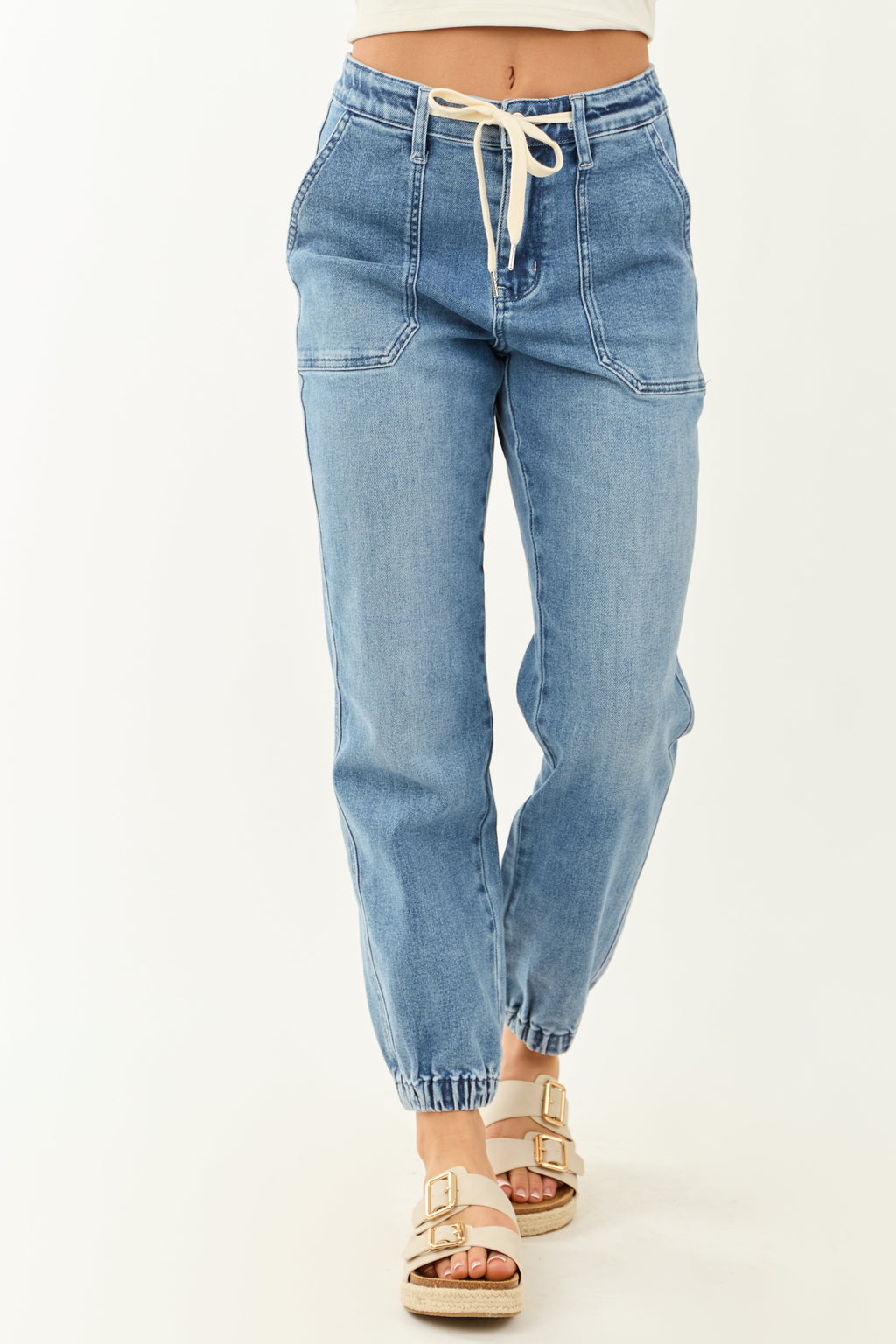 High-rise blue jogger jeans with a drawstring and pockets, featuring a relaxed fit and casual style. 3