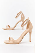Nude faux leather high heels with an ankle strap, featuring a sleek and comfortable design. 0