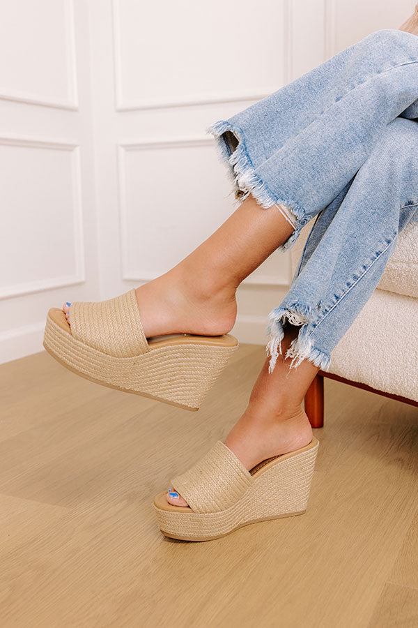 Tan jute wedge sandals with a wide woven strap and 4-inch heels, featuring a casual, bohemian style. 1