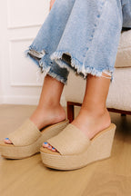Tan jute wedge sandals with a wide woven strap and 4-inch heels, featuring a casual, bohemian style. 2
