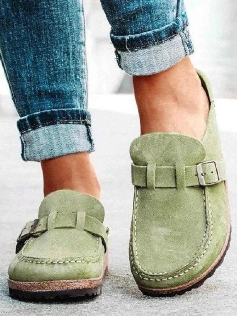 Brown suede clogs with a buckle and adjustable strap, featuring a comfortable and casual style. 1