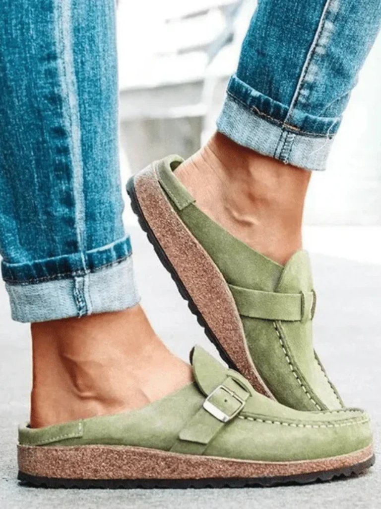 Brown suede clogs with a buckle and adjustable strap, featuring a comfortable and casual style. 2
