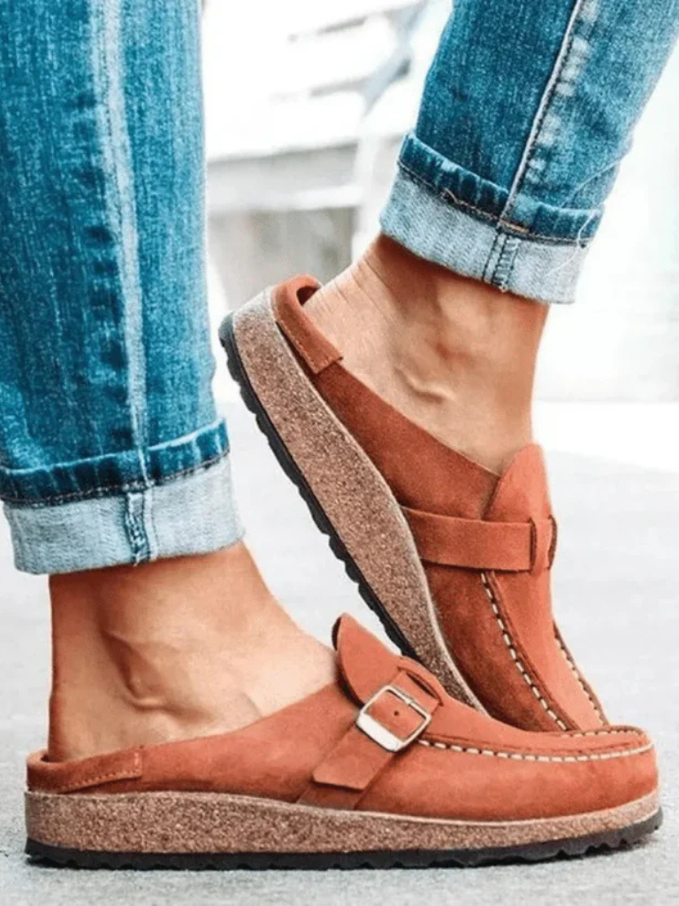 Brown suede clogs with a buckle and adjustable strap, featuring a comfortable and casual style. 4