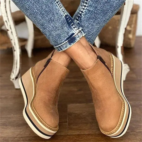 Black suede wedge ankle boots with a sleek, modern design and a subtle pointed toe. 1