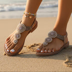 Beige bohemian flat sandals with an open vamp and colorful bead detail. 2